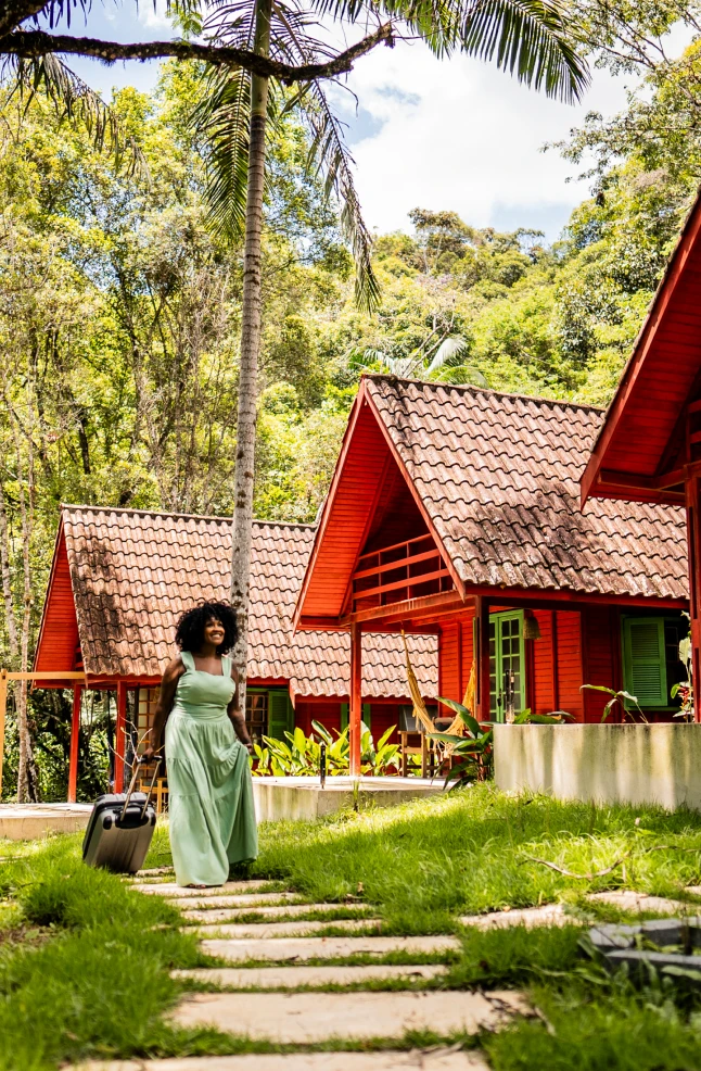 Woman with suitcase near red cabins