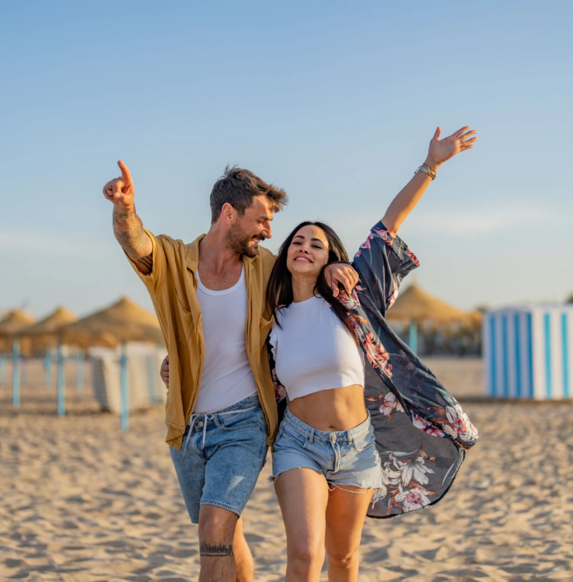 Happy pair walking on sandy shore