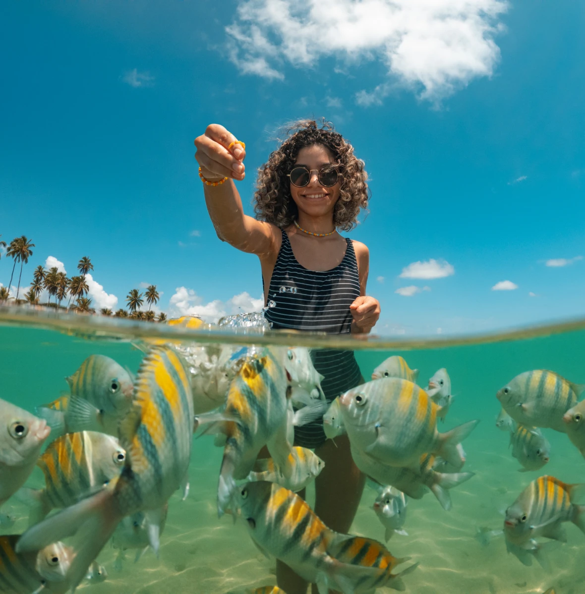 Woman enjoying beachside fish feeding